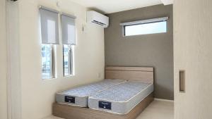 a bedroom with two beds in a room with two windows at Opt熊本益城 in Mashiki