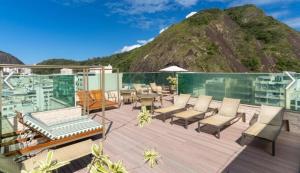 a balcony with chairs and tables and a mountain at Sant copacabana in Rio de Janeiro