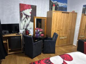 a room with a table and chairs and a television at Serenity Big Room in Brussels