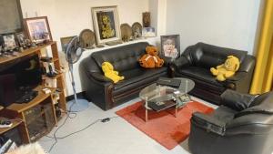 two stuffed animals sitting on a leather couch in a living room at RanaHansa Villa in Kegalle