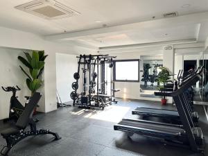 ein Fitnessstudio mit mehreren Laufbändern und Ergometern in der Unterkunft Luxee Haven in Manila