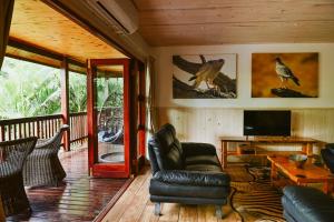 a living room with a leather chair and a television at Monzi Safari Lodge in Monzi