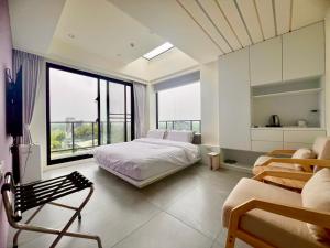 a bedroom with a bed and a large window at 有風別院民宿 登記編號3098 in Dongshan