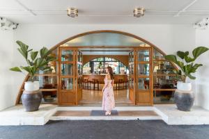 a woman in a dress standing in front of a doorway at Sugar Marina Hotel -POP- Kata Beach in Kata Beach