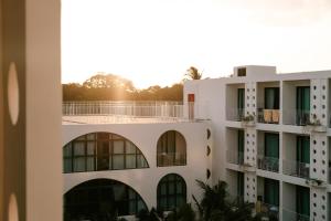 an apartment building with the sun in the background at Sugar Marina Hotel -POP- Kata Beach in Kata Beach