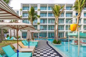 a hotel pool with chairs and umbrellas at Sugar Marina Hotel -POP- Kata Beach in Kata Beach +21 photos