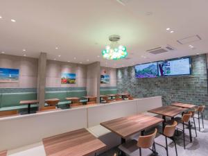 a dining room with wooden tables and chairs at The BREAKFAST HOTEL PORTO Ishigakijima in Ishigaki Island