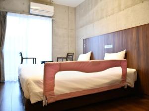 a bedroom with a large bed with a wooden headboard at The BREAKFAST HOTEL PORTO Ishigakijima in Ishigaki Island