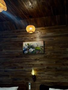 a room with a wooden wall with a painting and lights at Cham Trang An Retreat in Vũ Lâm