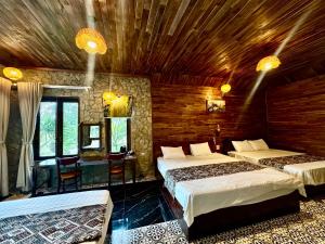 a bedroom with two beds and a table and chairs at Cham Trang An Retreat in Vũ Lâm
