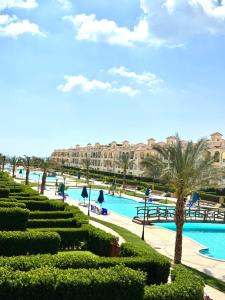 a resort with a swimming pool and palm trees at Lasirena Palm Beach Sokhna Chalet in Ain Sokhna