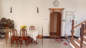 a dining room with a table and chairs and a clock at RanaHansa Villa in Kegalle