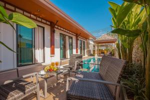 a patio with chairs and a table and a pool at Rawayana Villas in Rawai Beach