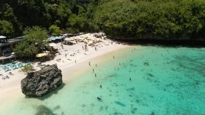 a group of people in the water at a beach at Jabeki Bungalows Bingin Beach, Uluwatu in Uluwatu
