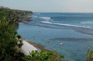a view of a beach with boats in the water at Jabeki Bungalows Bingin Beach, Uluwatu in Uluwatu +21 photos