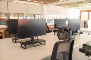 a row of monitors on a table in an office at BLive Coliving Canggu in Canggu +41 photos