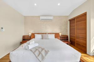 a bedroom with a white bed with towels on it at Summergrove Estate in Carool