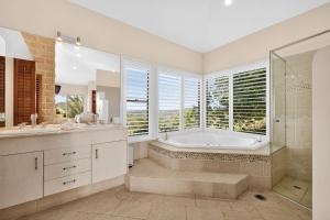 a bathroom with a tub and a shower and a sink at Summergrove Estate in Carool