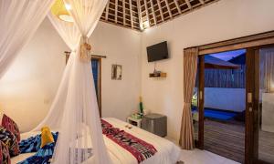 a bedroom with a bed with a mosquito net at Svaha Private Villas Ceningan in Nusa Lembongan