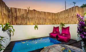 a backyard with a hot tub and pink pillows at Svaha Private Villas Ceningan in Nusa Lembongan