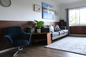 a living room with a couch and a chair at Neerim Country Cottages in Neerim South