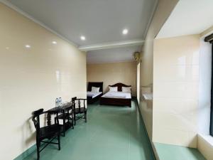 a bedroom with a bed and a table and chairs at Khách sạn AMI in Vinh
