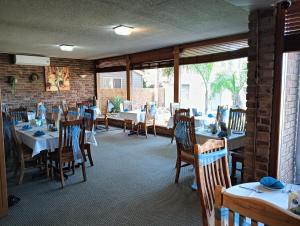 a restaurant with tables and chairs and a brick wall at Lakeside Inn Wollongong in Wollongong