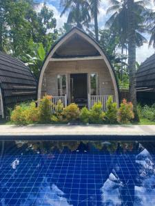 a small house with a pool in front of it at Sari Lumbung Bungalow in Penginuman +35 photos