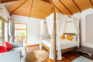 a bedroom with a bed with a canopy at Tewana Home Phuket in Phuket +49 photos