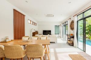 a living room with a wooden table and chairs at Tewana Home Phuket in Phuket