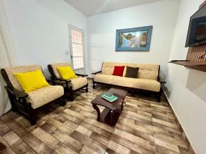a living room with two chairs and a table at A Casa di Minas in Três Corações