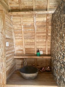 a bathroom with a large stone sink in a wooden wall at Sari Lumbung Bungalow in Penginuman
