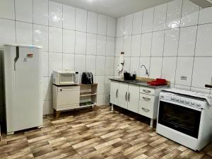 a kitchen with white appliances and a white refrigerator at A Casa di Minas in Três Corações