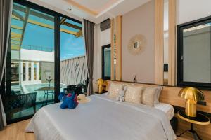 a bedroom with a large bed and a large window at Rawayana Villas in Rawai Beach