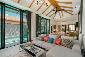 a living room with a couch and a table at Rawayana Villas in Rawai Beach