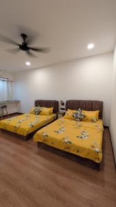 two beds in a room with a ceiling fan at Zulis Haven Stay in Kuala Rompin