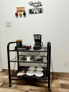 a coffee cart with plates and a coffee maker on it at A Casa di Minas in Três Corações +18 photos