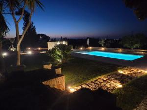 a swimming pool in a yard at night at Depéndance in Polignano a Mare
