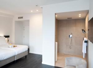 ein Schlafzimmer mit einer Dusche und einem Bett sowie ein Badezimmer in der Unterkunft Hotel Portinari in Brügge