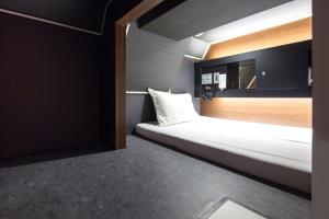 a room with a bed and a mirror at commun SHIBUYA (Male Only) in Tokyo