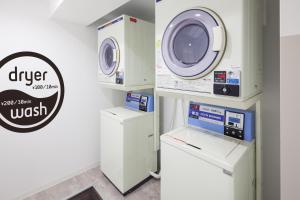 eine Waschküche mit Waschmaschine und Waschmaschine in der Unterkunft commun SHIBUYA (Male Only) in Tokio