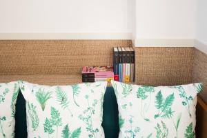 a bed with a pillow and books on it at Hotel Casa Bonay & Spa in Barcelona