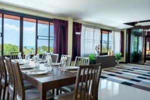 a dining room with a long table and chairs at 6 Bedrooms Seaview With Pool - Belle Sunset Villa in Ko Lanta