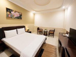 a bedroom with a large white bed and a desk at Mong Yen Hotel in Cao Lãnh +47 photos