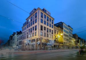 een hoog gebouw in een stadsstraat 's nachts bij Aparthotel Residence Agenda in Brussel