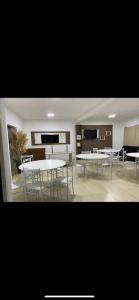 a dining room with white tables and chairs at Hotel Serrano in Inácio Martins