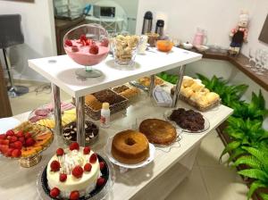 a shelf with various desserts and pastries on it at Hotel Serrano in Inácio Martins