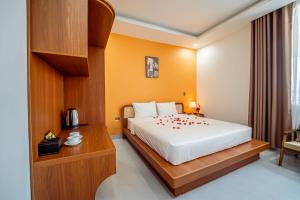 a hotel room with a bed with red flowers on it at Cát Boutique Hotel in Dong Hoi