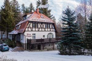 uma casa com um telhado de gambrel na neve em Mon Plaisir em Karpacz