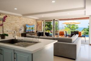 a kitchen and living room with a couch and a table at Amazing Seaview Apartment in Ko Lanta
